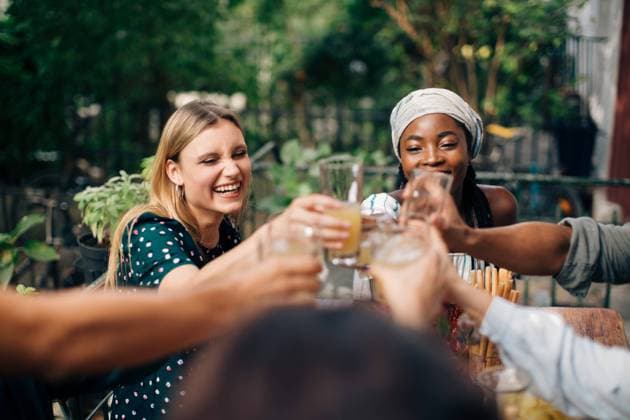 Multi-ethnic friends toasting drinks while sitting at balcony , model released, property released Copyright: xMaskotx , MA68100