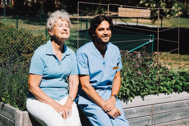 IMAGO Creative: Zivildienst und ehrenamtliches Engagement Smiling senior woman sitting with male nurse on planter at back yard , model released, property released Copyright: xMaskotx , MA68868