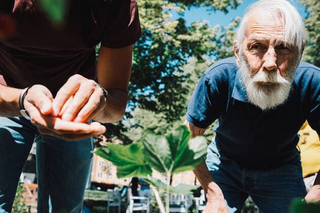 IMAGO Creative: Zivildienst und ehrenamtliches Engagement Retired senior man standing by male volunteer at back yard , model released, property released Copyright: xMaskotx , MA68875