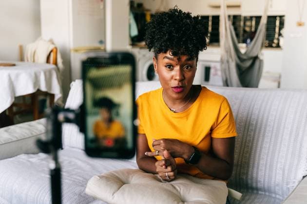 IMAGO Creative: Digitale Welt, Social Commerce Cheerful young African American female blogger recording video on smartphone while preparing content for social networks at home Copyright: xJakexJakabx Model Released