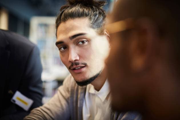 Creative businessman looking at male colleague during meeting in office , model released, property released Copyright: xMaskotx , MA69185