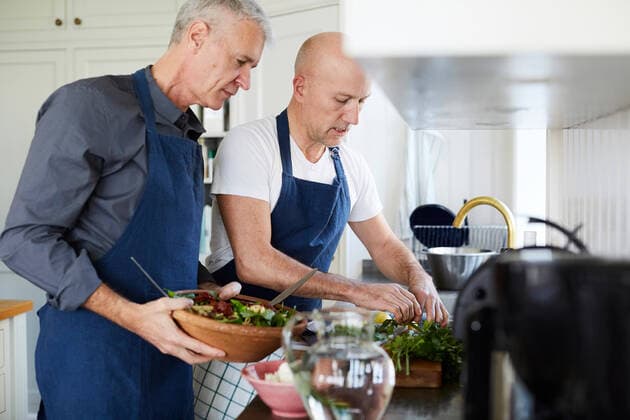IMAGO Creative: Clickbait, Rezepte und Kochen Mature men talking while cooking food in kitchen at home , model released, property released Copyright: xMaskotx , MA69509