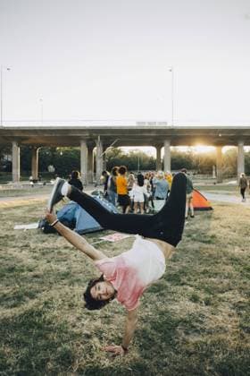 IMAGO Creative: NGO, Kunst im öffentlichen Raum und Kulturinitiativen Young man dancing on grass while enjoying in festival against clear sky , model released Copyright: xMaskotx , MA69771