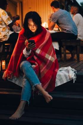 Young woman using smart phone while friends in background during dinner party , model released, property released Copyright: xMaskotx , MA70308