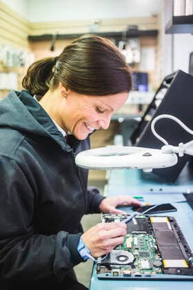 Side view of smiling mature technician working on computer part in workshop , model released, property released Copyright: xMaskotx , MA70472