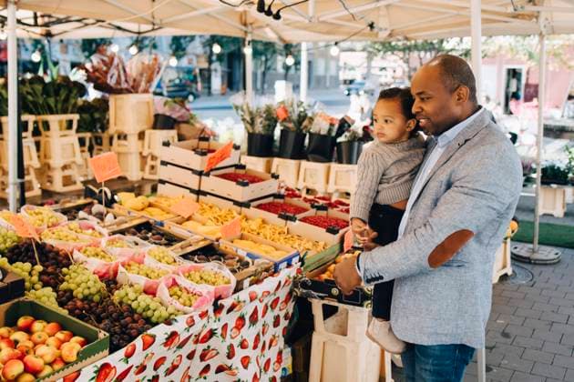 IMAGO Creative, Urban Lifestyle Father carrying daughter while buying fruit and vegetables in market , model released Copyright: xMaskotx , MA70735
