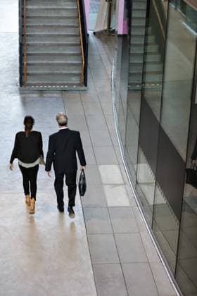 Rear view of male and female colleagues walking in lobby , model released, property released Copyright: xMaskotx , MA70879