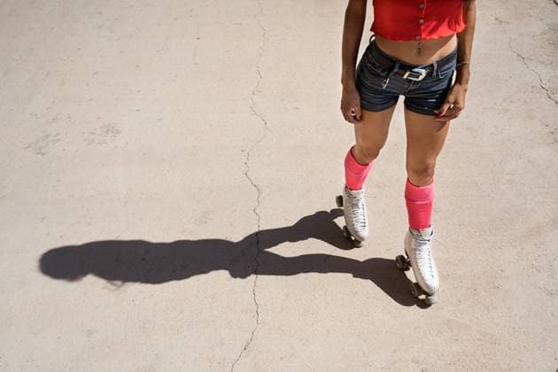Concentrated female roller skating on sports ground on sunny day in city Copyright: xJavierxBallesterx Model Released