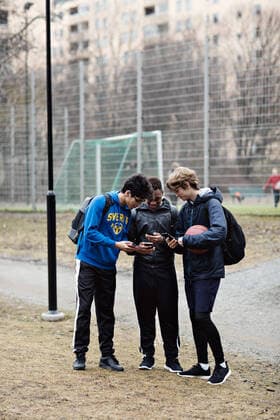 IMAGO Creative: Sport Start-Up Full length of social media addicted friends wearing sports clothing while using mobile phones on playing field , model released Copyright: xMaskotx , MA71128