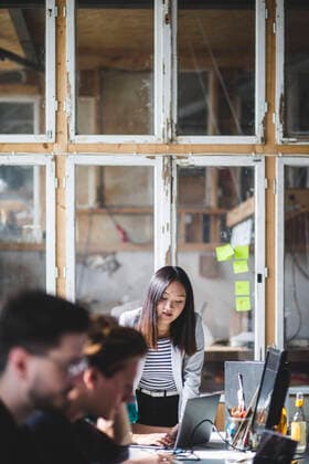 Confident female IT professional looking at colleague coding in laptop at workplace , model released, property released Copyright: xMaskotx , MA71822