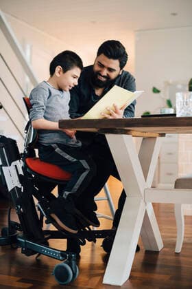 Father teaching autistic son while sitting at table in living room , model released, property released Copyright: xMaskotx , MA72554