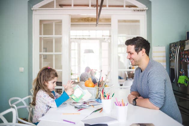 IMAGO Creative: Jahreszeit Winter, Fantasievoll drinnen spielen Smiling father looking at girl holding picture book in kitchen , model released, property released Copyright: xMaskotx , MA72816