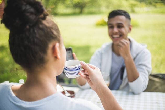 IMAGO Creative: Landleben - Alfresco, Draußen Smiling teenage boy looking at female friend drinking coffee in restaurant , model released, property released Copyright: xMaskotx , MA72974
