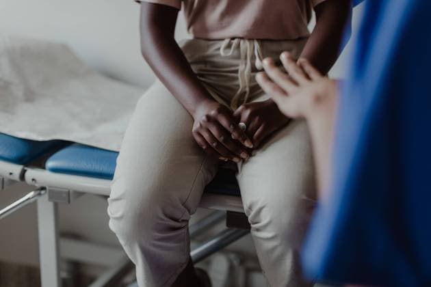 IMAGO Creative: Brustkrebsmonat Midsection of female healthcare worker explaining to young patient in medical clinic , model released, property released Copyright: xMaskotx , MA73859