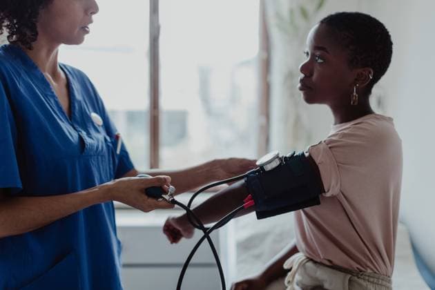 IMAGO Creative: NGO, Rehabilitation und Gesundheitswesen Nurse examining blood pressure of young female patient in medical examination room , model released, property released Copyright: xMaskotx , MA73861