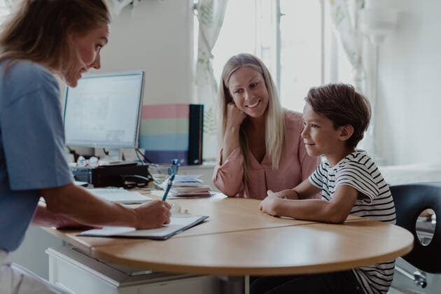 IMAGO Creative: Bildung, Schreiben Mother and son consulting female pediatrician at desk in clinic , model released, property released Copyright: xMaskotx , MA73951