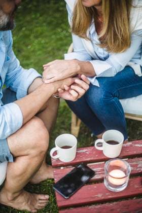 High angle view of mature couple holding hands while sitting at backyard during coffee time , model released, property released Copyright: xMaskotx , MA73983