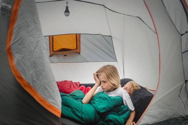 Girl rubbing eyes while waking up by brother in tent during camping , model released, property released Copyright: xMaskotx , MA74515