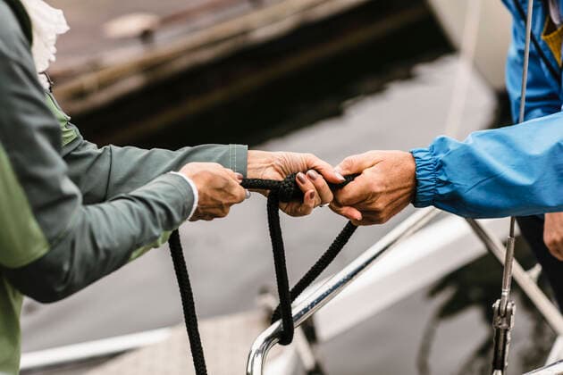 Cropped hands of female instructor and senior man tying rope on yacht s railing , model released, property released Copyright: xMaskotx , MA75490