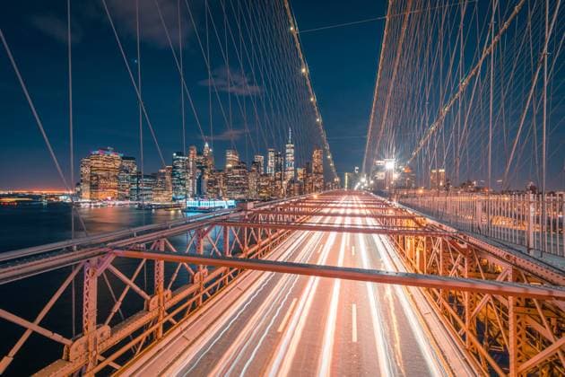 Empty roadway of illuminated Brooklyn bridge at night time with glowing skyscrapers in background in New York City, Model released Copyright: xJavierxMartinezx MR