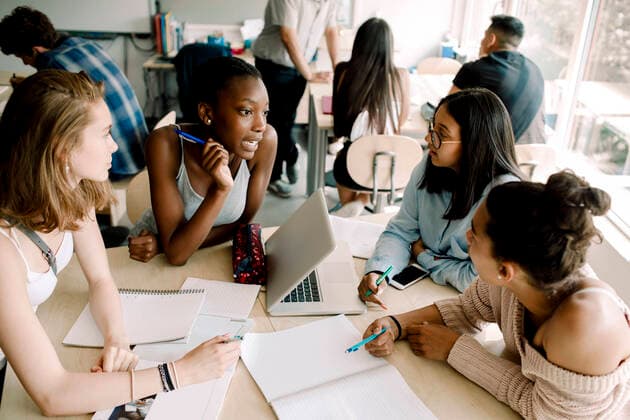 Teenage girls discussing while sitting by table in classroom , model released, property released Copyright: xMaskotx , MA77571