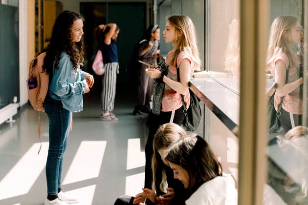 Female students communicating in school corridor during lunch break , model released, property released Copyright: xMaskotx , MA77618