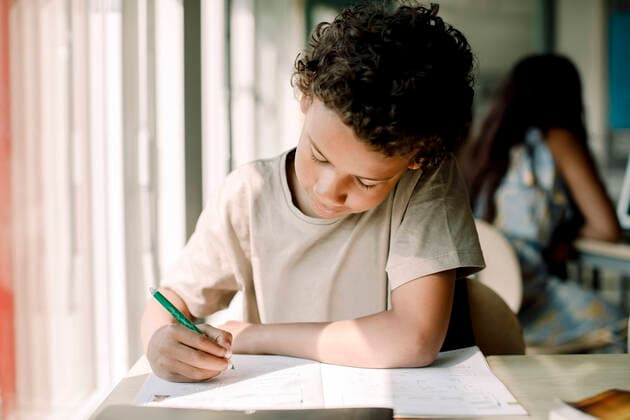 Male student writing while sitting in classroom , model released, property released Copyright: xMaskotx , MA77637