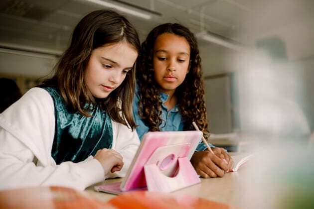 Female students using digital tablet at table in classroom , model released, property released Copyright: xMaskotx , MA77660