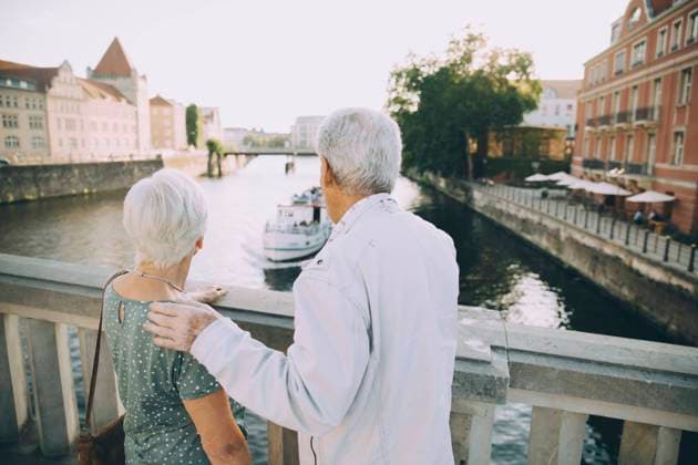 IMAGO Creative, Jahreszeit Sommer, Sommer in der Stadt Rear view of senior couple standing on bridge against railing in city , model released Copyright: xMaskotx , MA77996