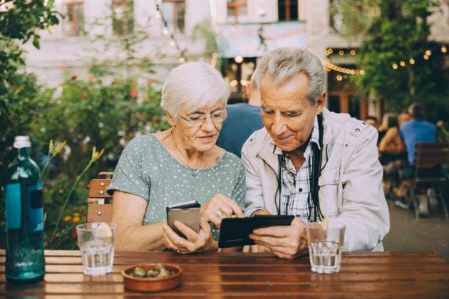 IMAGO Creative, Urban Lifestyle IMAGO Creative: Urban Diversity Senior couple using smart phone while sitting at restaurant in city , model released Copyright: xMaskotx , MA78021