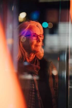 Senior woman looking away while standing in city at night , model released Copyright: xMaskotx , MA78145