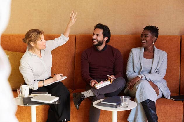 Female entrepreneur discussing with businessman and businesswoman while sitting on sofa at workplace , model released, property released Copyright: xMaskotx , MA78417