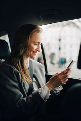IMAGO Creative: Kreative Renaissance -- der junge Entrepreneur Smiling entrepreneur using smart phone while sitting in taxi Germany, Hamburg, model released Copyright: xMaskotx , MA79095