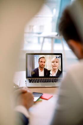 Colleagues having video call over laptop with business professionals in office Sweden, Stockholm, model released, property released Copyright: xMaskotx , MA79507