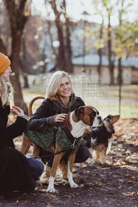 IMAGO Creative: Landleben - Alfresco, Draußen Portrait of smiling blond woman crouching by friend with dogs at park Sweden, Stockholm, model released Copyright: xMaskotx , MA79793