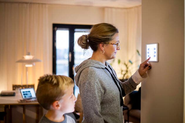 IMAGO Creative: Corporate: Klimaschutz, Digitalisierung und Urbanisierung Son looking at mother using digital tablet mounted on wall at smart home Sweden, Stockholm, model released, property released Copyright: xMaskotx , MA80404