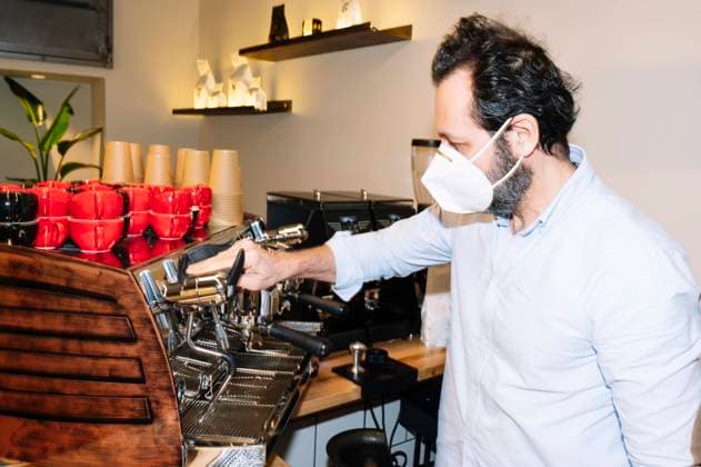 Side view of barista cleaning coffee machine in cafe Copyright: xJosexLuisxCarrascosax Model Released