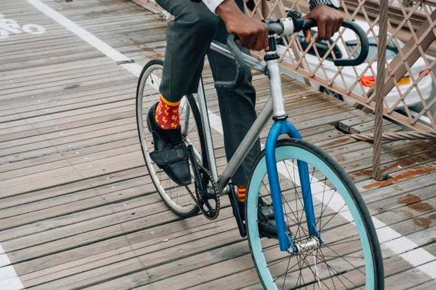 IMAGO Creative: Sport Start-Up Cropped anonymous well dressed businessman cyclist in riding bike on wooden road among red metal structure with in New York city Copyright: xJosexLuisxCarrascosax Model Released
