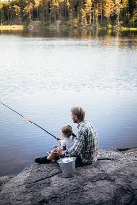 IMAGO Creative: Vaterschaft Father and daughter fishing while sitting by lake Sweden, Stockholm, model released Copyright: xMaskotx , MA81534