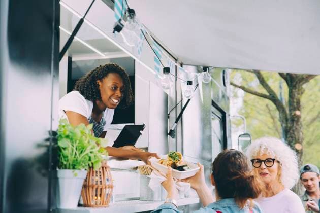 Female owner giving indian food to smiling customers in city Sweden, Stockholm, model released, property released Copyright: xMaskotx , MA81597