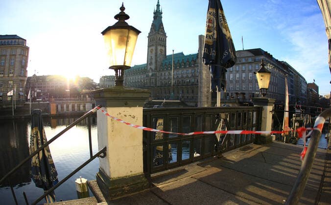 Flatterband sperrt den Zugang zu einem während des Lockdowns geschlossenen Restaurant bei den Alsterarkaden ab. Im Hintergrund das Hamburger Rathaus. Altstadt Hamburg