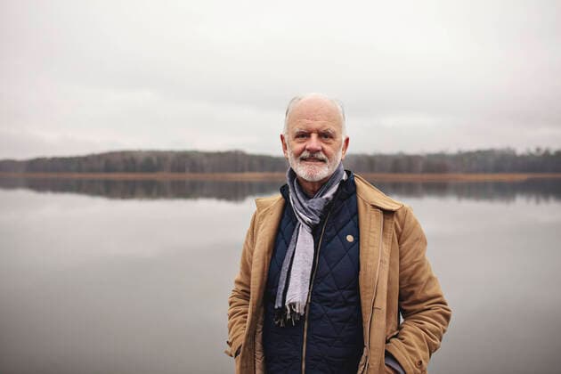 IMAGO Creative: Wintersport, Mode Portrait of smiling senior man with hands in pockets standing against lake Sweden, Stockholm, model released Copyright: xMaskotx , MA81819