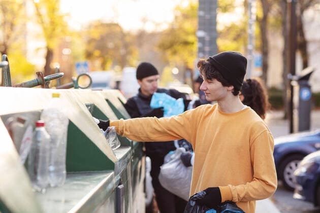 IMAGO Nature: Unsere Erde, Umweltverträgliche Herausforderungen, Recycling Smiling male environmentalist throwing plastic waste in garbage can Sweden, Stockholm, model released Copyright: xMaskotx , MA81936