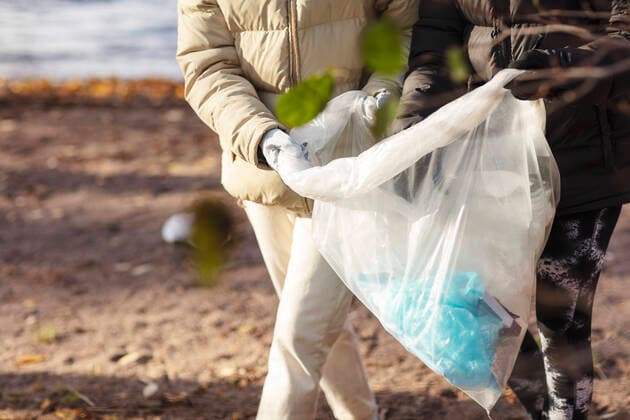 Midsection of female environmentalists holding plastic filled with garbage by lake Sweden, Stockholm, model released Copyright: xMaskotx , MA81987