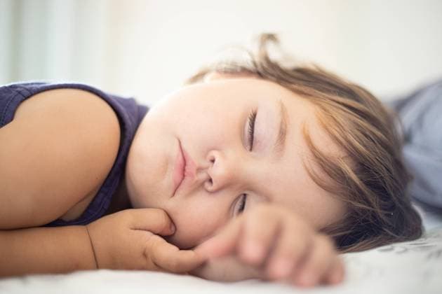 Adorable toddler peacefully sleeping on comfortable bed in cozy light bedroom at home Copyright: xJosxTempranox Model Released