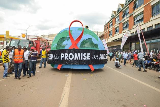 Kampala, Uganda - October. 2:blue and green half round figure with inscription promise on AIDS in center of densely populated road at Kampala Festival Copyright: xJuanxAlbertoxRuizx Model Released