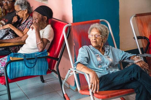 IMAGO Creative: NGO, Rehabilitation und Gesundheitswesen LA HABANA, CUBA - NOVEMBER, 6 , 2018: Side view elderly African American people sitting on?seats in room with ventilator in Cuba Copyright: xKikexArnaizx Model Released
