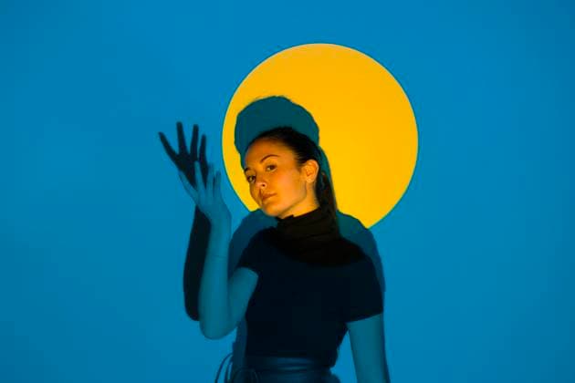 Young woman moving in blue light in front of yellow circle model released Symbolfoto property released ALBF01205