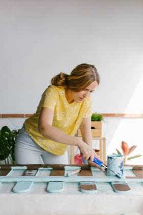 IMAGO Creative: Clickbait, Deko Ideen f?r Zuhause Young blonde woman painting an old fence for her terrace Copyright: xLightsyx Model Released