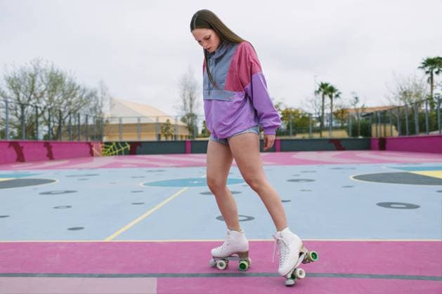 IMAGO Creative, Lifestyle, Frühling in der Stadt Low angle of young female in trendy sportswear with quad roller skates training on colorful playground in spring day Copyright: xLightsyx Model Released